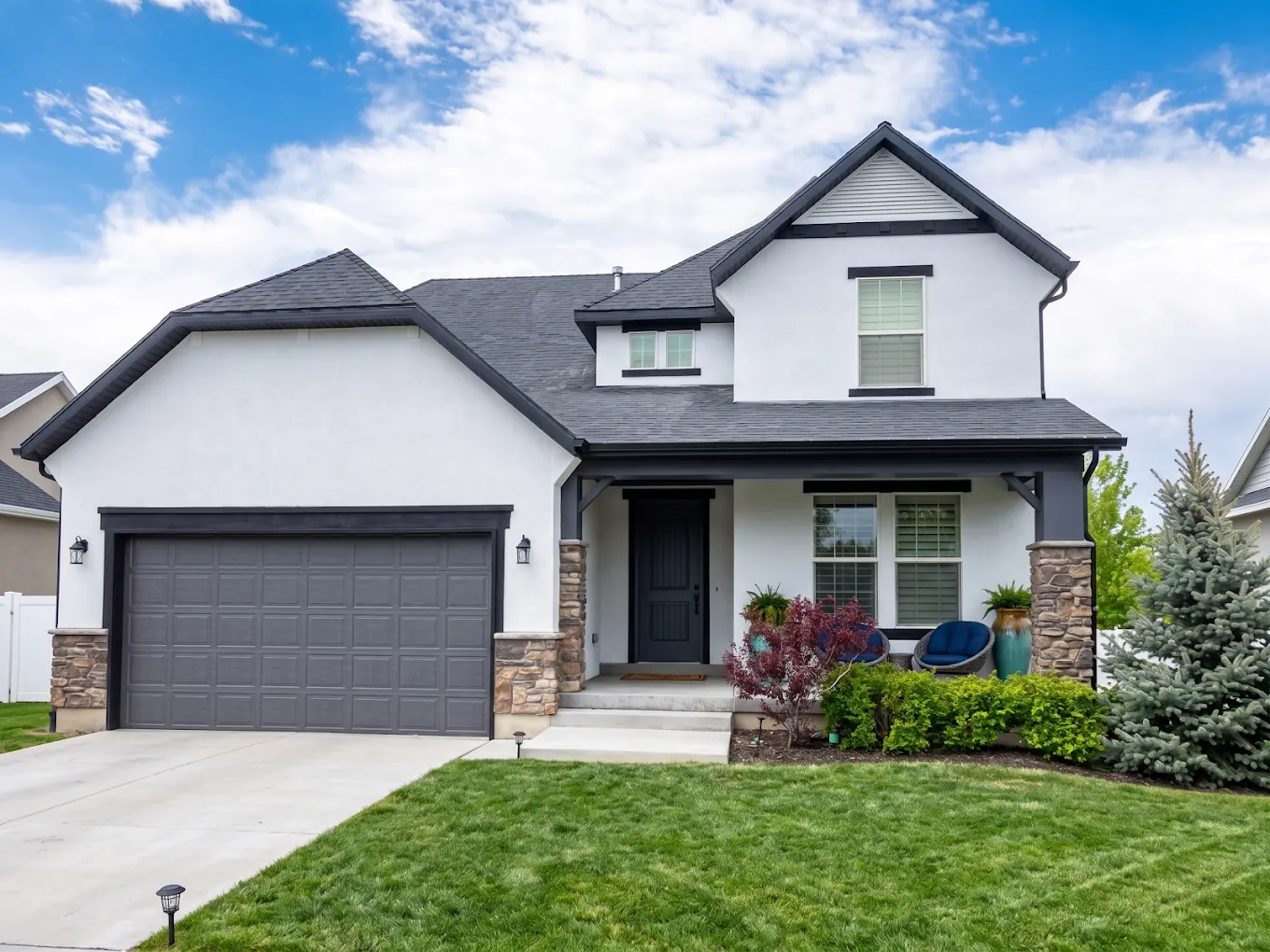 Two story home with fresh white stucco and black trim after an exterior repaint