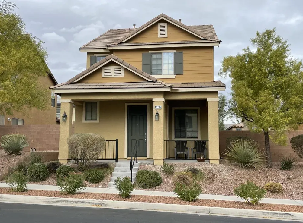 Two story Las Vegas home with freshly painted stucco, trim, and front door